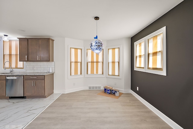 unfurnished dining area with a sink, baseboards, plenty of natural light, and visible vents