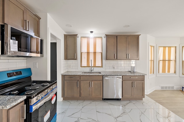 kitchen featuring stainless steel appliances, visible vents, a sink, and marble finish floor