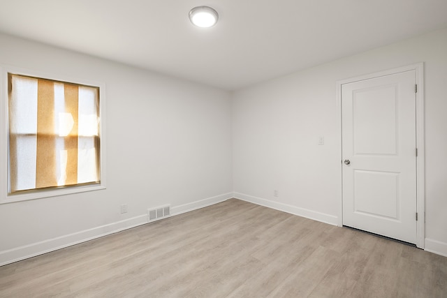 unfurnished room with baseboards, light wood-style flooring, and visible vents