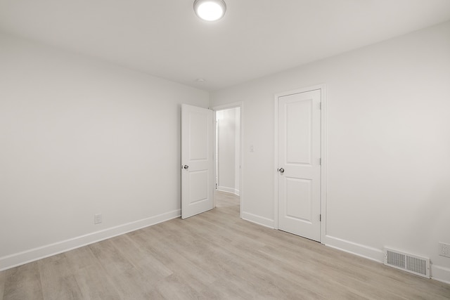 unfurnished bedroom with baseboards, light wood finished floors, and visible vents
