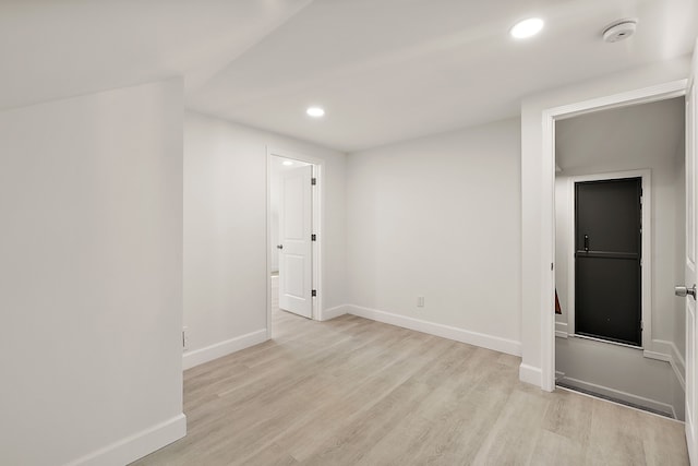 spare room featuring baseboards, recessed lighting, and light wood-style flooring
