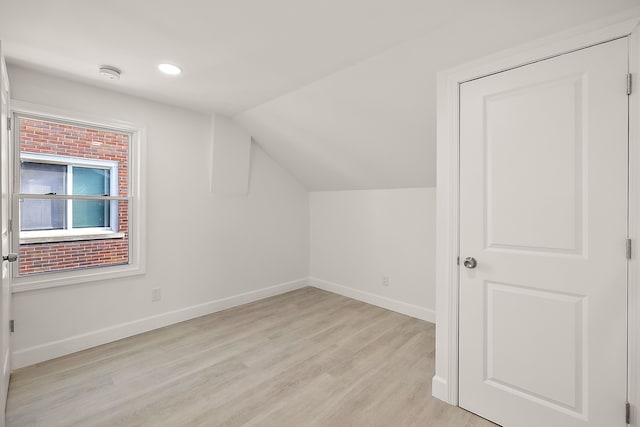 additional living space featuring recessed lighting, baseboards, lofted ceiling, and light wood-style floors