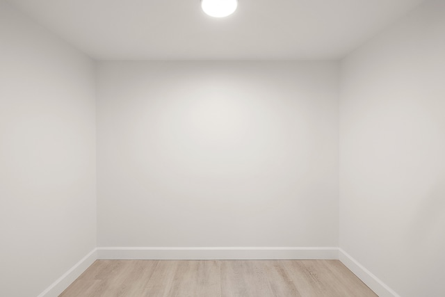 spare room with baseboards and light wood-style flooring