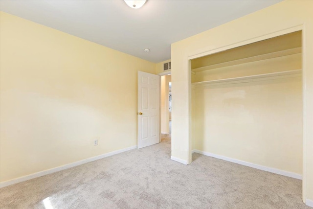 unfurnished bedroom featuring baseboards, carpet, visible vents, and a closet