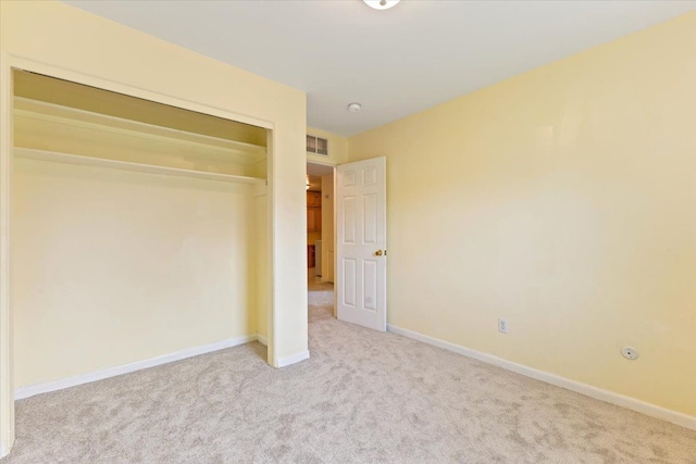 unfurnished bedroom with baseboards, visible vents, carpet, and a closet