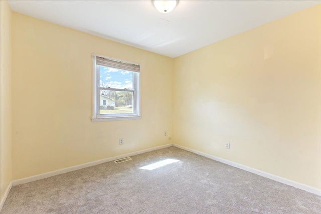 carpeted empty room with visible vents and baseboards