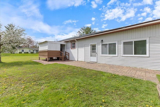rear view of house featuring a lawn, entry steps, and a patio area