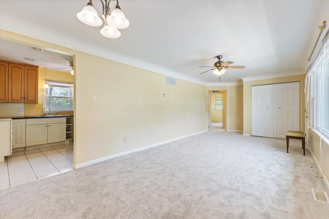 unfurnished bedroom with a sink, baseboards, visible vents, and light colored carpet