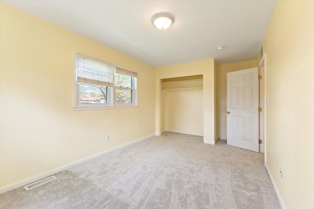 unfurnished bedroom featuring baseboards, carpet, a closet, and visible vents