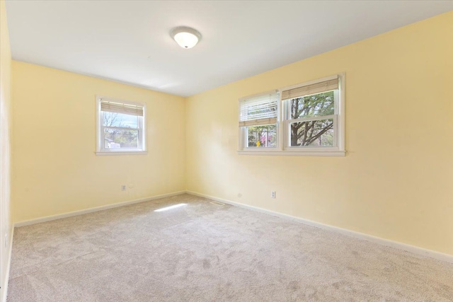 empty room featuring baseboards and carpet flooring