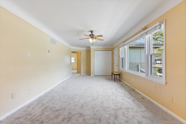 interior space featuring baseboards, visible vents, ceiling fan, and a wealth of natural light