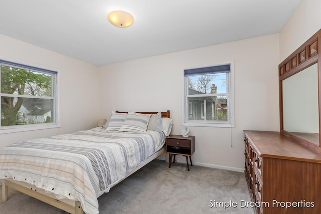 bedroom with baseboards and light carpet