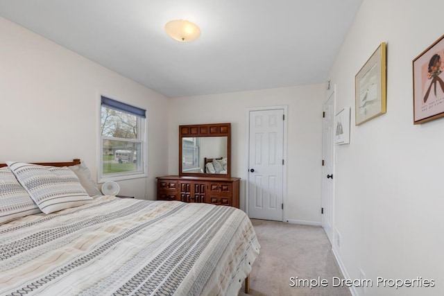 bedroom with baseboards and light carpet