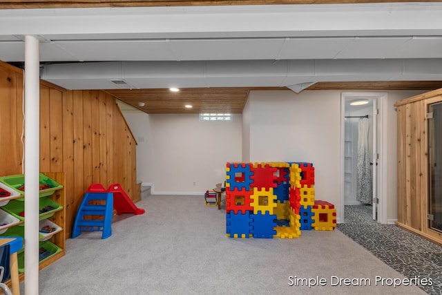 rec room with carpet floors, wooden walls, baseboards, and recessed lighting