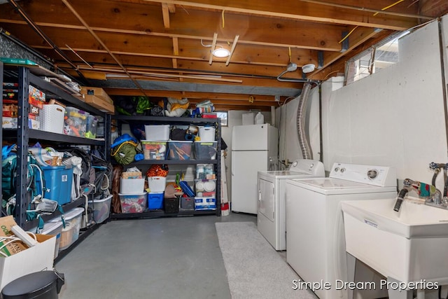 interior space with a sink, freestanding refrigerator, and washing machine and dryer