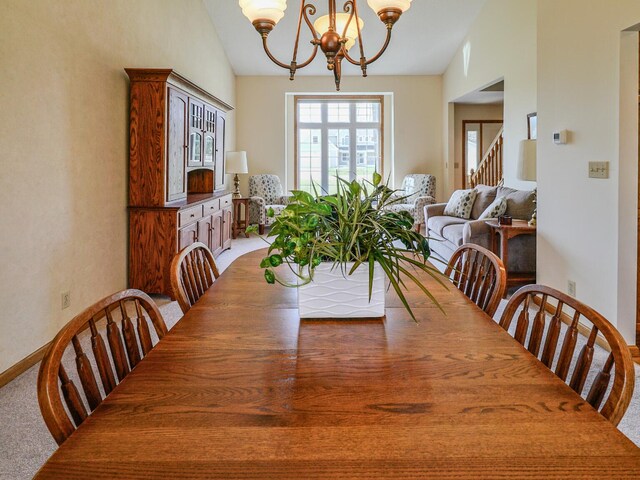 dining space with an inviting chandelier, light carpet, and vaulted ceiling