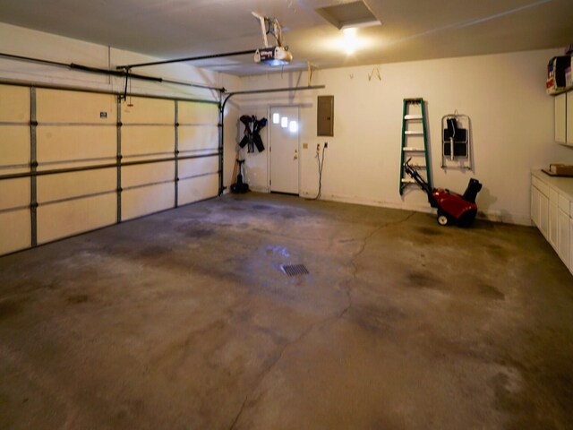garage with a garage door opener and electric panel