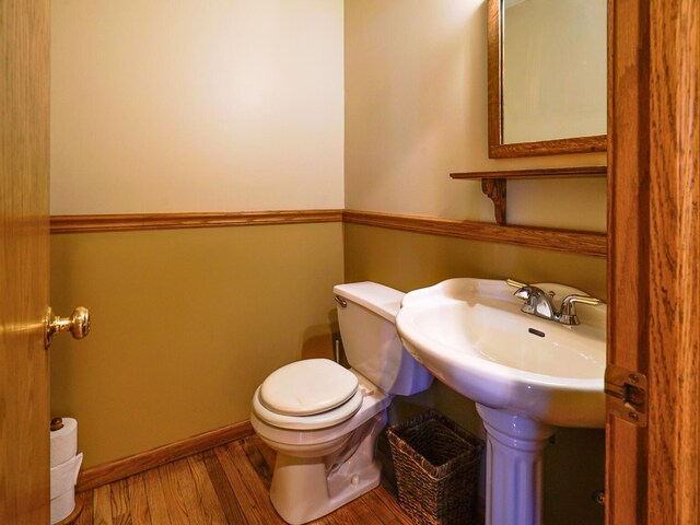 half bathroom featuring toilet and wood finished floors