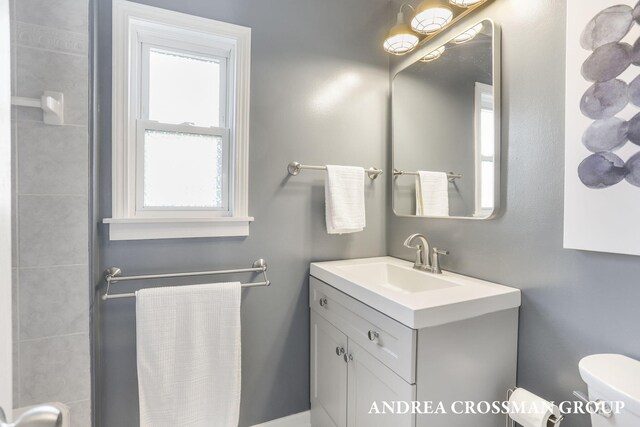 bathroom featuring vanity, plenty of natural light, and toilet