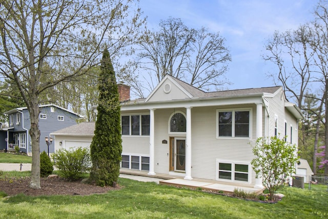 4741 Pin Oak Trl, Jackson, MI 49201 - split foyer home with a garage, a front yard, a chimney, and central AC unit