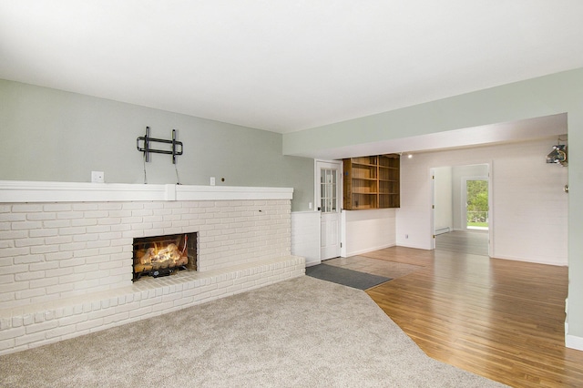 4741 Pin Oak Trl, Jackson, MI 49201 - unfurnished living room with baseboards, a brick fireplace, and wood finished floors