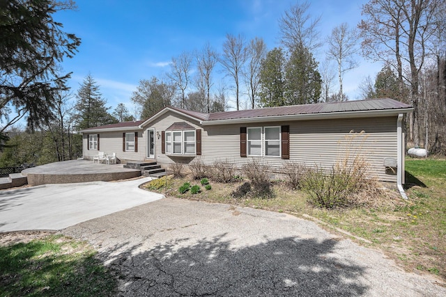 1499 N Apple Dr, White Cloud, MI 49349 - view of front facade featuring metal roof and aphalt driveway