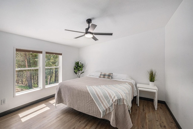 bedroom with baseboards, ceiling fan, and wood finished floors