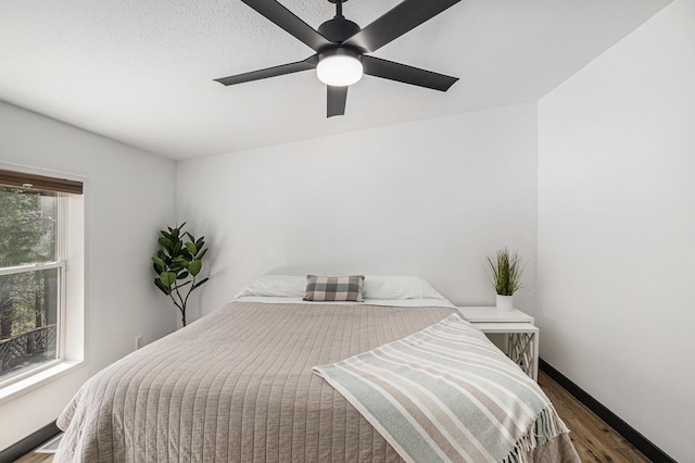 bedroom with baseboards, ceiling fan, and wood finished floors