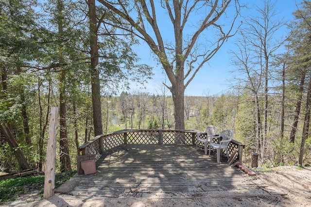 wooden terrace featuring a forest view