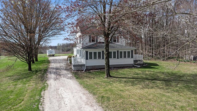 view of side of property with a yard and driveway