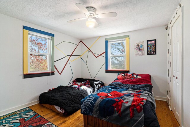 bedroom featuring multiple windows, a closet, and wood finished floors