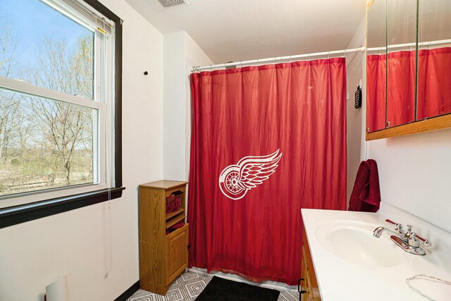 full bath with a healthy amount of sunlight, vanity, a shower with shower curtain, and visible vents