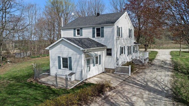exterior space featuring a gate, roof with shingles, driveway, and a front yard
