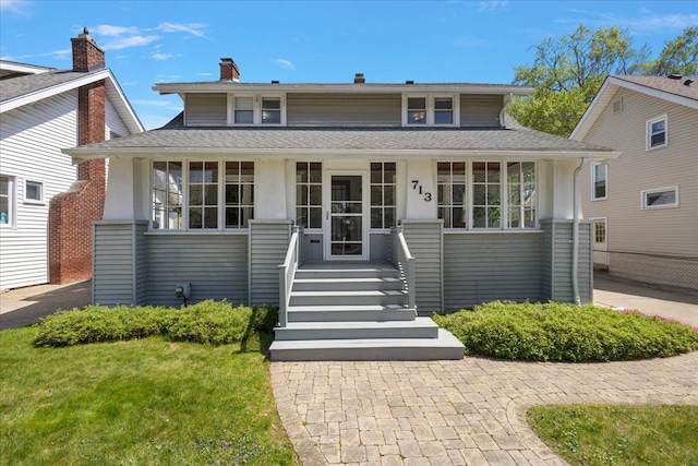 view of front of property featuring covered porch and a shingled roof