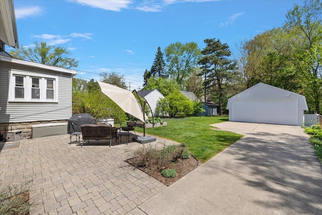 view of patio with a detached garage, an outbuilding, and area for grilling