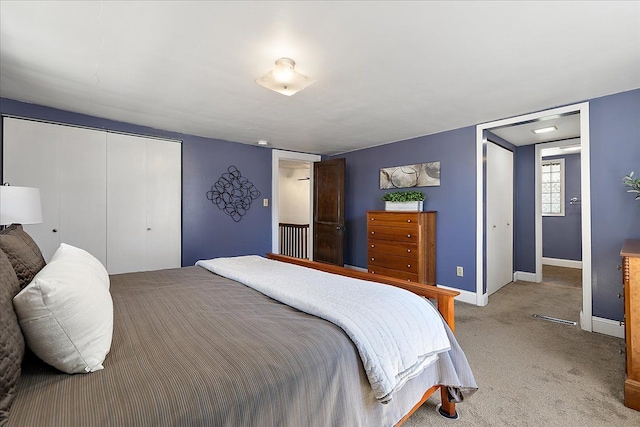 bedroom featuring light colored carpet, baseboards, and a closet
