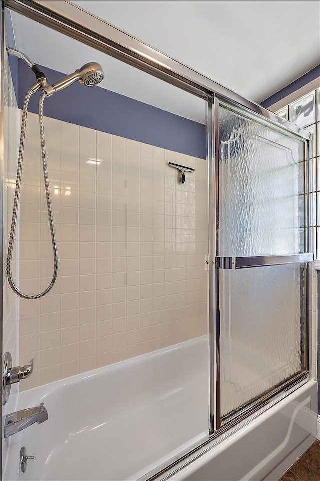 bathroom with shower / bath combination with glass door