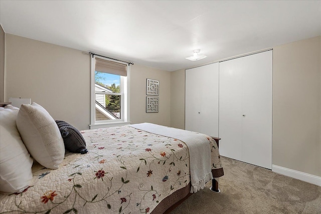 bedroom with baseboards, light carpet, and a closet