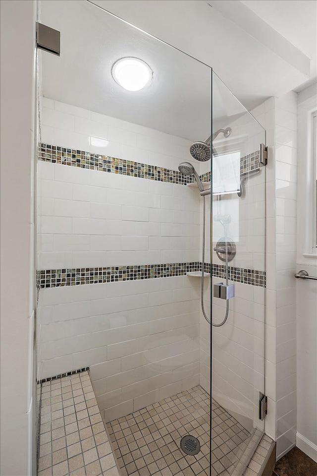 full bath featuring tile patterned flooring and a shower stall