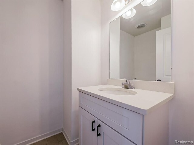 bathroom featuring vanity, baseboards, and visible vents