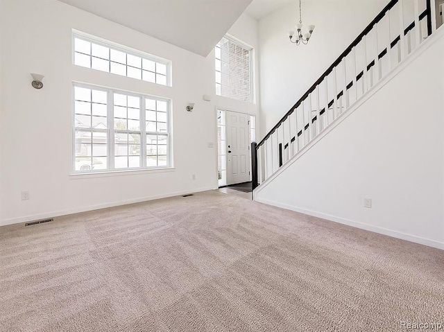 foyer entrance with baseboards, carpet, a chandelier, and visible vents
