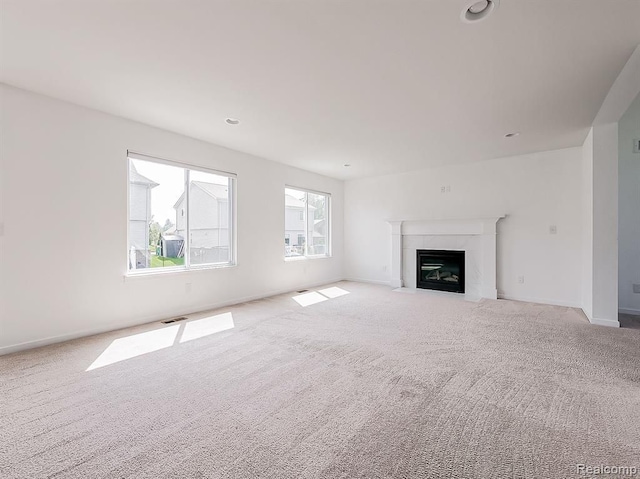 unfurnished living room featuring carpet floors, baseboards, visible vents, and a premium fireplace