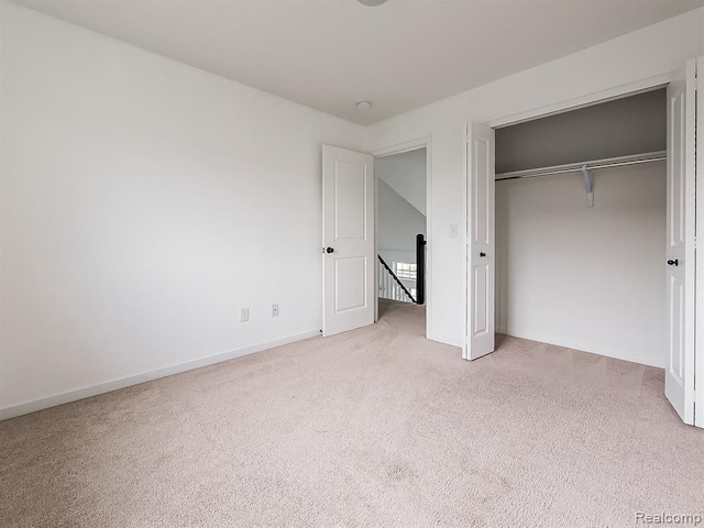 unfurnished bedroom featuring carpet floors, baseboards, and a closet