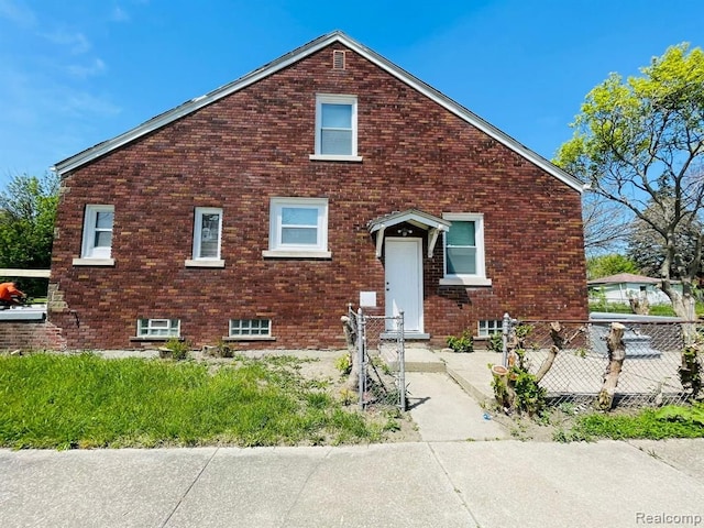 view of front of home featuring fence and brick siding