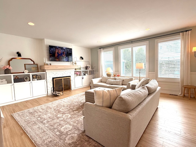 living area featuring recessed lighting, a fireplace, and light wood-type flooring
