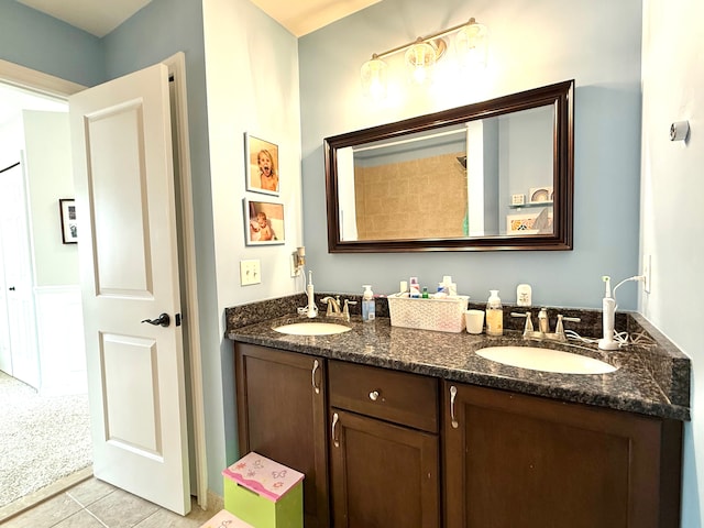 full bath with double vanity, tile patterned floors, and a sink