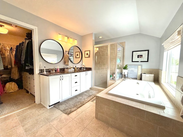 full bathroom featuring tile patterned flooring, double vanity, a shower stall, lofted ceiling, and a bath