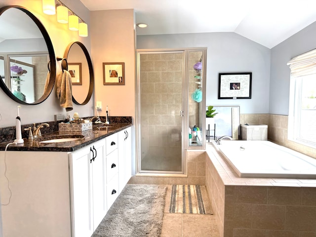 bathroom with lofted ceiling, a bath, tile patterned floors, a shower stall, and a sink