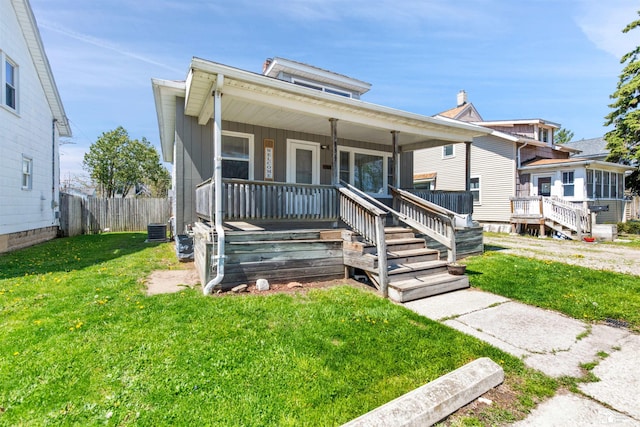 934 Smith St, Monroe, MI 48161 - bungalow-style house with central air condition unit, fence, covered porch, and a front yard