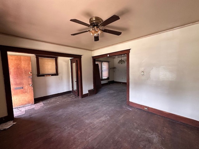 unfurnished room featuring baseboards, dark wood-type flooring, and ceiling fan